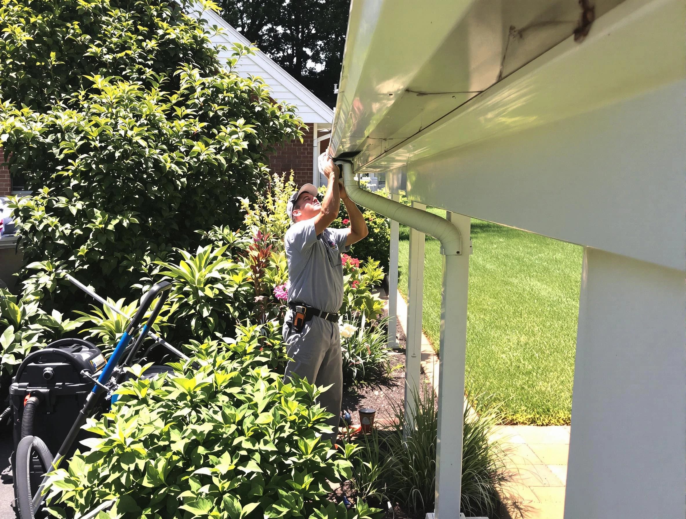 Technician flushing a blockage from a downspout in Lyndhurst, OH